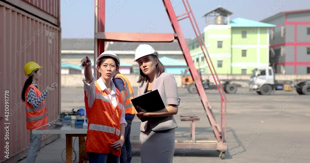 Logistics warehouse workers are supervising the unloading of container boxes from a cargo ship for export or import, Logistics industry, Import and export business concept. Logistics warehouse workers are supervising the unloading of container boxes from a cargo ship for export or import, Logistics industry, Import and export business concept.