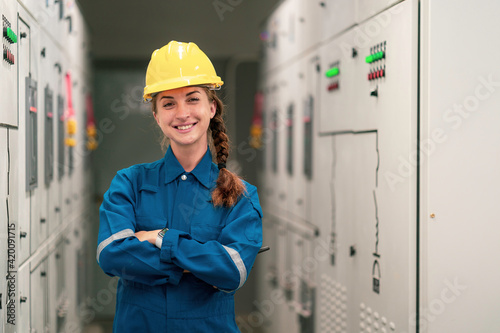 Portrait shot half body of young female electrical engineer in electrical control room, action thump up showing the good services working and professional concept.