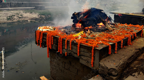 Burning Hindu funeral pyre,Hindu funeral rights of burning the body on a tall wooden funeral pyre in Nepal photo