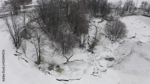 global warming causing irregular ice build up and rapid melts in stream photo