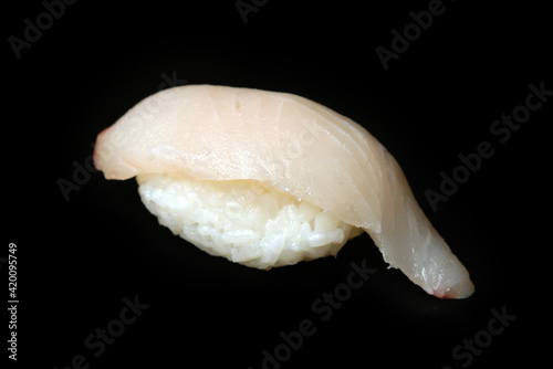 sushi with white fish on a black background healthy food