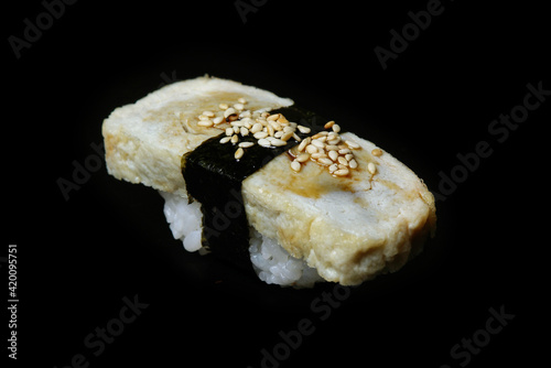 sushi with a piece of omelet isolated on a black background useful dietary food