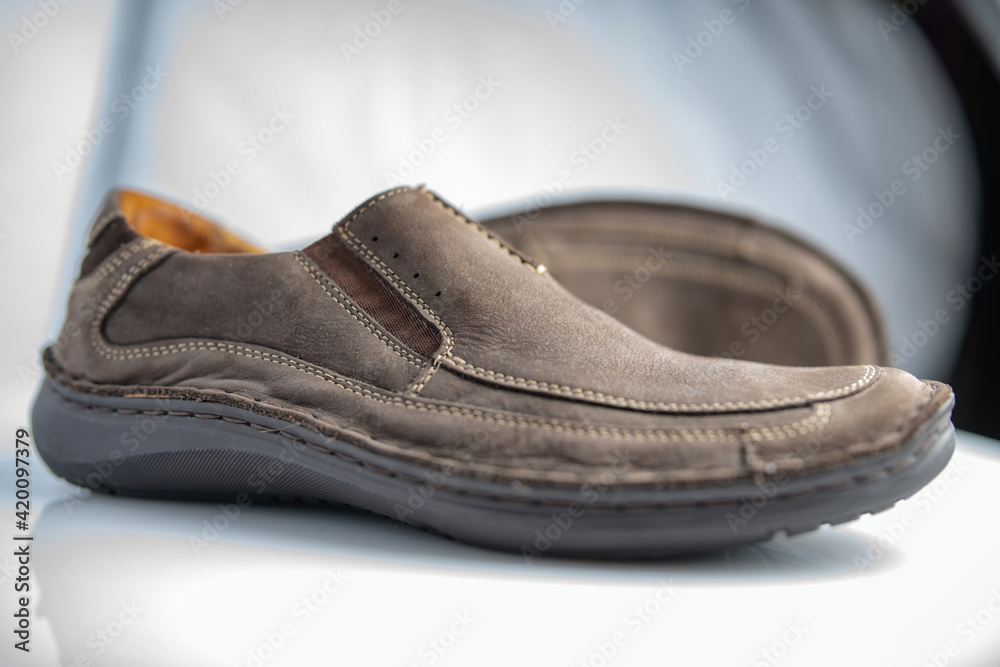 Men's leather loafers of brown color close-up on a light background. Men's leather loafers of brown color close-up on a light background.