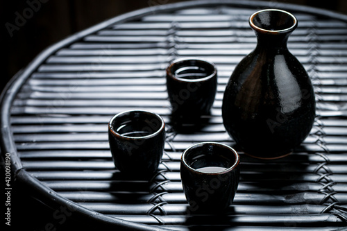 Sake in black ceramics on black table. Japanese cuisine.