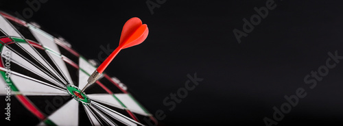 Obraz na płótnie Darts board with red dart arrow on center of dartboard