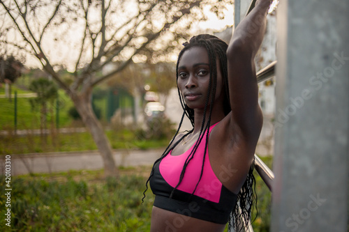 profile view of a beautiful black woman honding an iron exercisin bar. Fitness routine photo