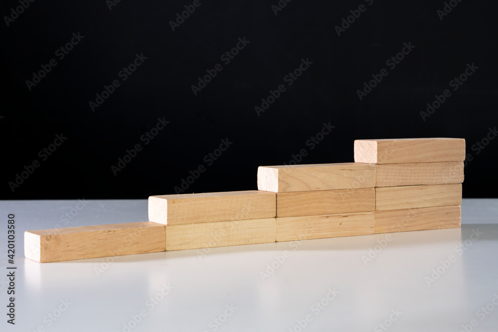Steps on a stairs made of wooden blocks.Moving up a career ladder