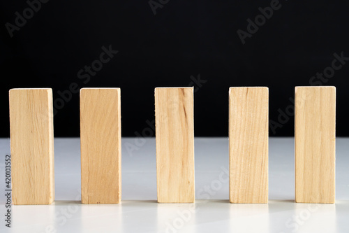 Business relationship concept arranging small wooden block on white background.Domino effect.