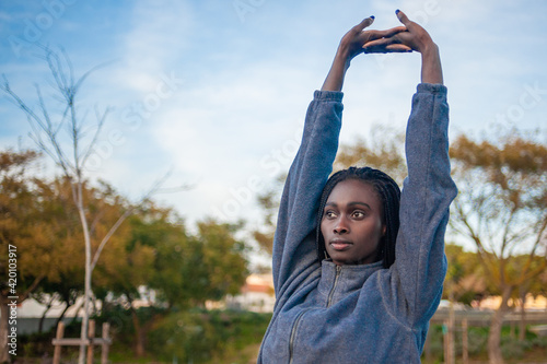 black woman streching her arms exercising outside. great copy space.
