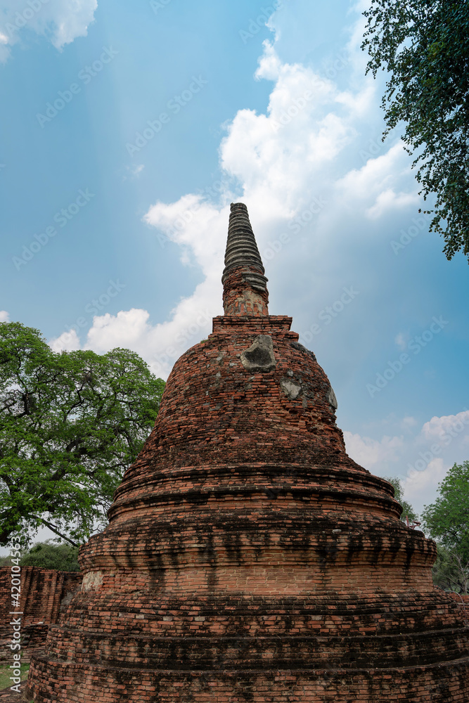 closeup broken and bending ancient pagoda (chedi) ruins of old Siam capital Ayutthaya at Wat Phra Si Sanphet temple, famous place for travelling in Phra Nakhon Si Ayutthaya, Thailand