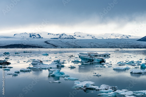 Icebergs in Jokulsarlon glacial lagoon while a snow storm is approaching the area in famous Icelandic travel location