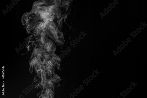 White vapor spray steam from air saturator. Smoke fragments on a black background. Abstract background