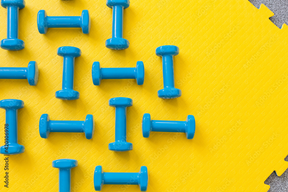 Blue dumbbells on yellow background pattern Blue dumbbells on yellow background pattern