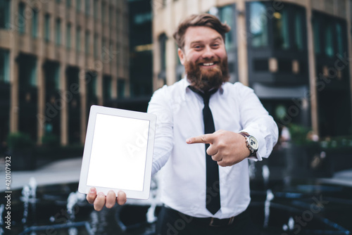 Smiling man pointing at tablet screen