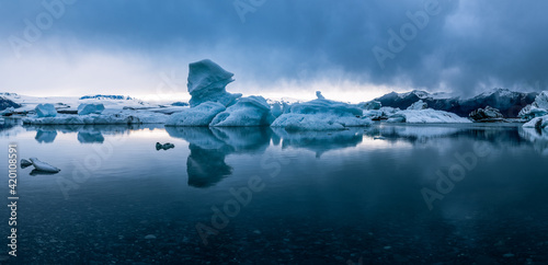 Panoramic view of icebergs in Jokulsarlon glacial lagoon while a snow storm is approaching the area in famous Icelandic travel location