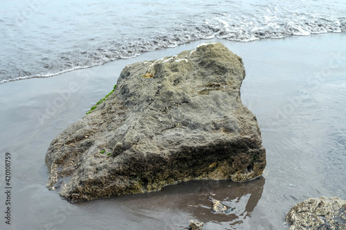 Fototapeta Naklejka Na Ścianę i Meble -  Rock on the black sand of the beach.