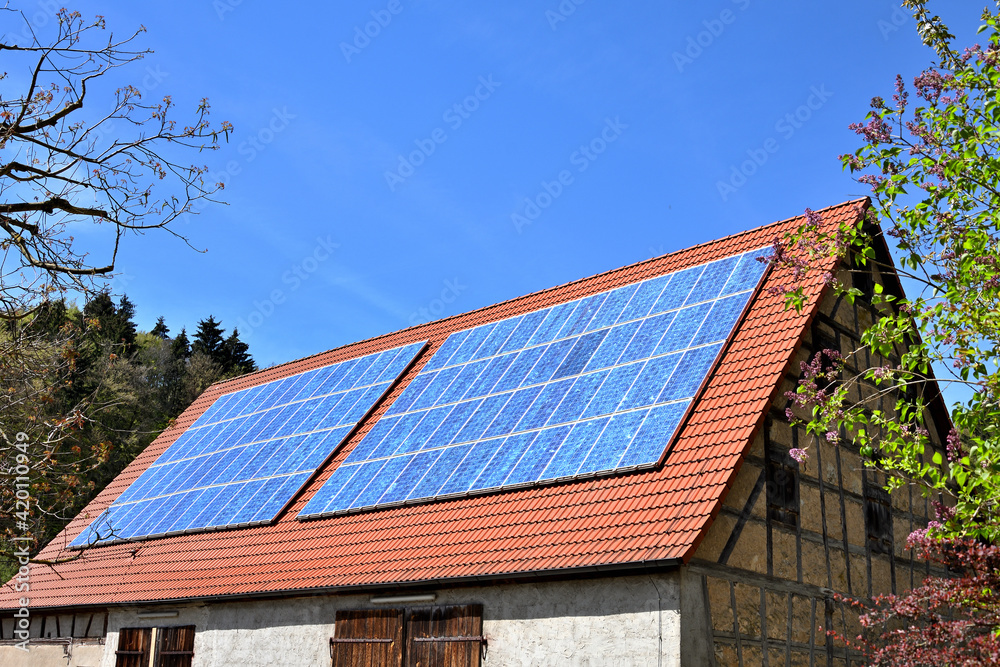 Fototapeta premium Solarkollektoren auf rotem Scheunendach