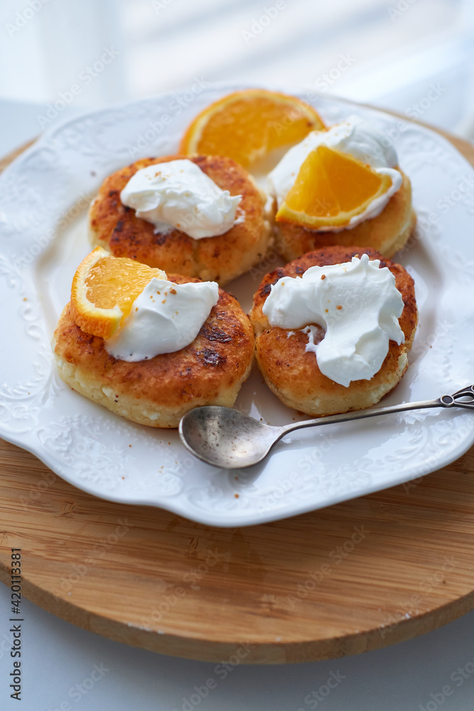 baked cottage cheese tortillas, sirniki with sour cream and orange peel