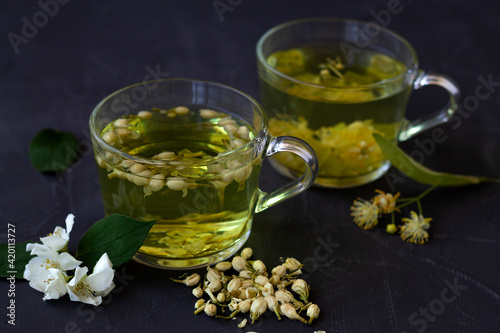 cup of tea. close up Jasmine tea. two cups of hot herbal tea with linder flowers on a black table. Healthy lifestyle. glass cups of green tea on a black background. Hot drinks.