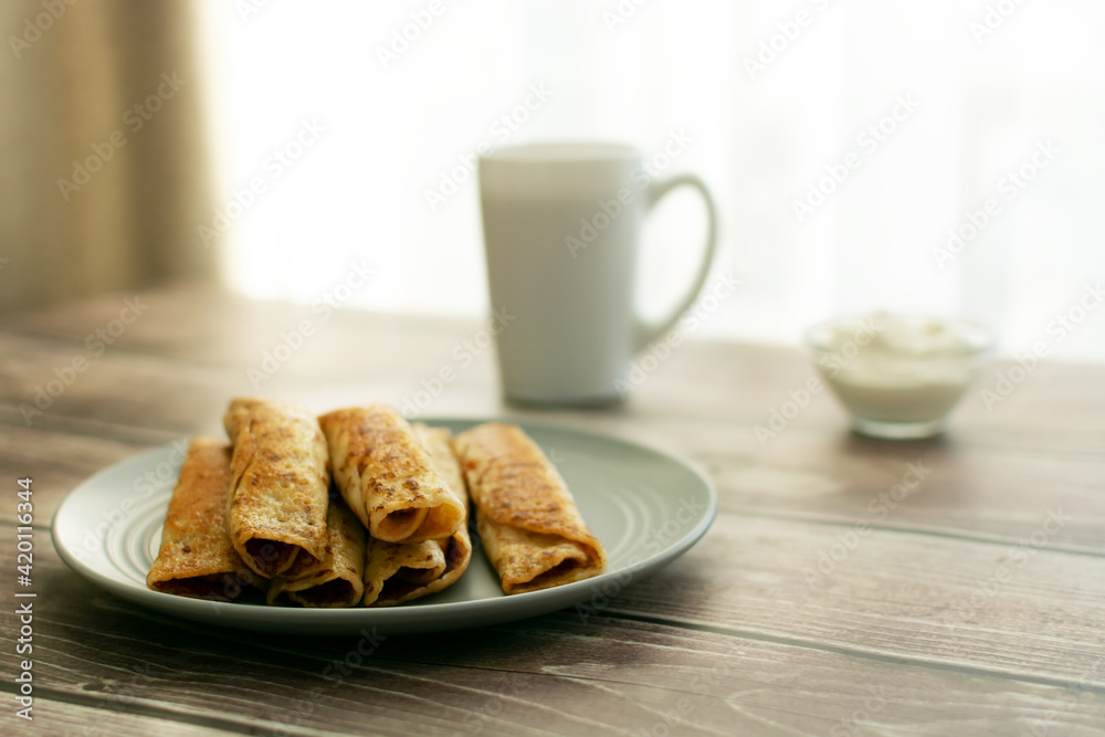 Pancakes on a gray plate, a cup on a wooden table Pancakes on a gray plate, a cup on a wooden table