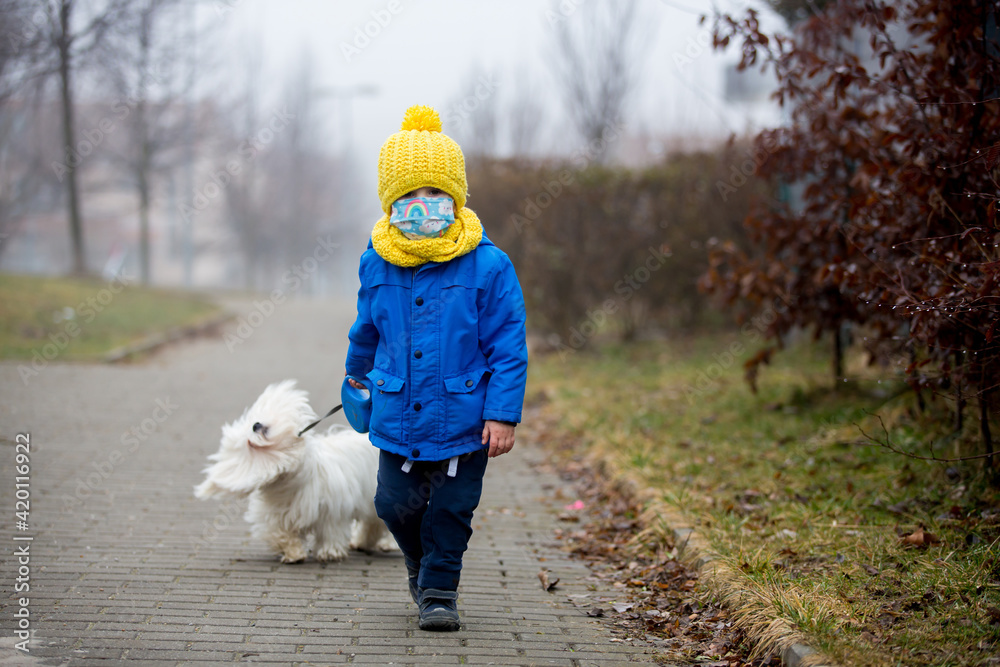 Little toddler child, boy, wearing medical mask while on little walk during the Covid lockdown Little toddler child, boy, wearing medical mask while on little walk during the Covid lockdown