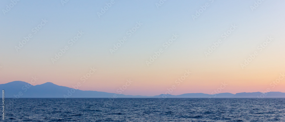 Seascape with fog and mountains. Seascape at sunset. Dramatic scenes and the beauty of nature