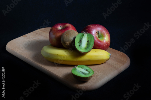  colorful fruits bananas apples and kiwi isolated on black