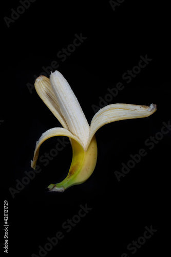 Opened banana ready to eat isolated on black