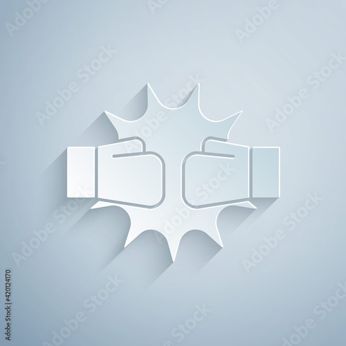 Paper cut Punch in boxing gloves icon isolated on grey background. Boxing gloves hitting together with explosive. Paper art style. Vector