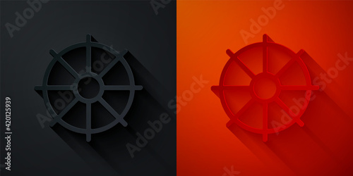 Paper cut Dharma wheel icon isolated on black and red background. Buddhism religion sign. Dharmachakra symbol. Paper art style. Vector