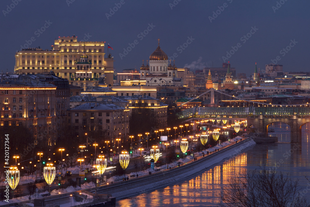 Dark blue sunset with city lights and reflections in Moscow river. Travel concept.