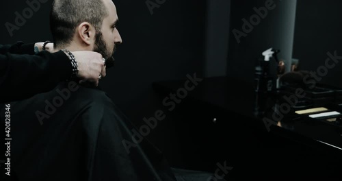 Close-up of barber cuts the hair by scissors at barbershop. photo