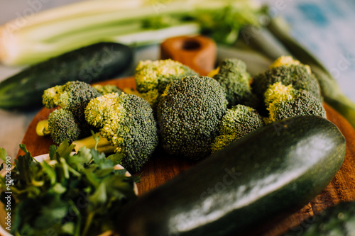 Green vegetables background with broccoli, cucumber, courgette and celery. Healthy, organic and vegan food.	