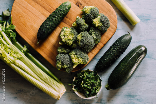Green vegetables background with broccoli, cucumber, courgette and celery. Healthy, organic and vegan food.	