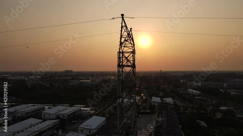 Transmission poles The electric poles travel through the high-voltage poles within the village and contrast with the beautiful sky at sunset. Energy efficiency concept