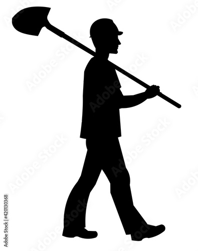 Silhouette of a worker in work clothes walks with a shovel on his shoulder