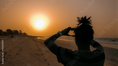 African beach orange sunset. People / community get together at the evening time. Kotu beach, The Gambia