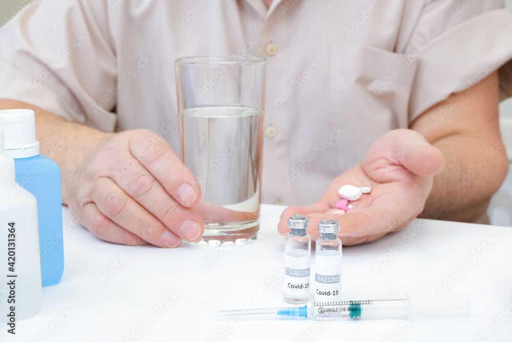 Taking pills, a glass of water in the hand of an elderly person. Taking pills, a glass of water in the hand of an elderly person.