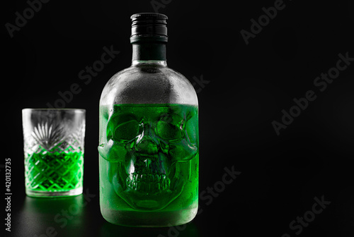 Green skull absinthe bottle on dark background