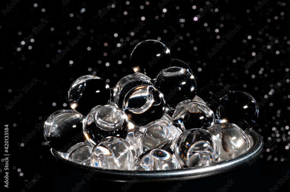Gray caviar cup in glittered black background close-up view
