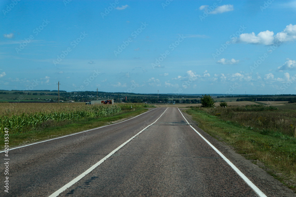 asphalt road in the countryside surrounded by field, russian outback