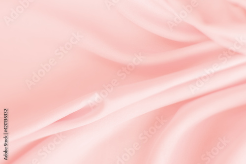 Close-up delicate pink silk fabric background. Empty space for text. Flat lay top-down. Feel the sense of timeless luxury. Wavy silk fabric - soft background and texture styled concept