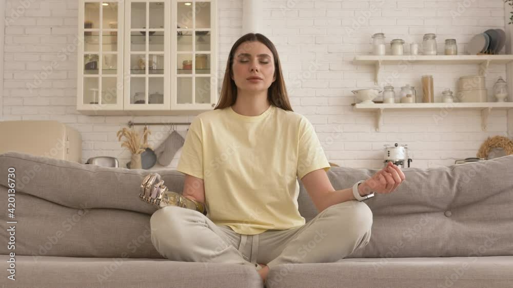 Calm woman with metal bionic arm does breathing exercises Calm woman with metal bionic arm does breathing exercises