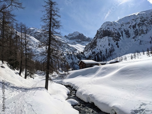 Breathtaking mountain landscape near the alp Sertig. Snow mountains with Sun, Snow a river and beautiful trees, Swiss photo