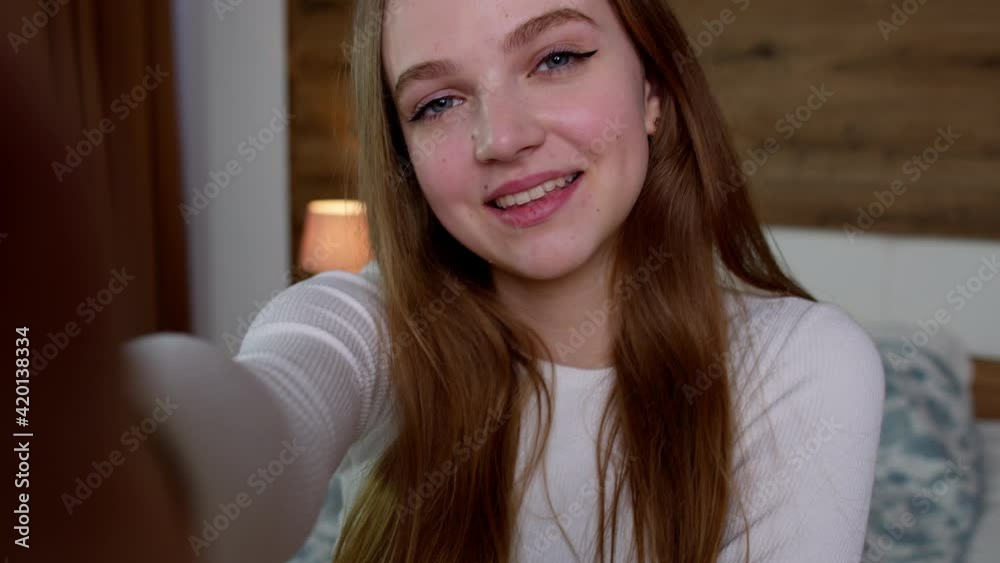 POV shot of young smiling woman blogger makes selfie on smartphone for social media networks at home POV shot of young smiling woman blogger makes selfie on smartphone for social media networks at home