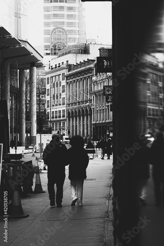 London UK February 2021 Black and white vertical shot of a couple walking the streets of london on Valentines day  together on a cold winter day