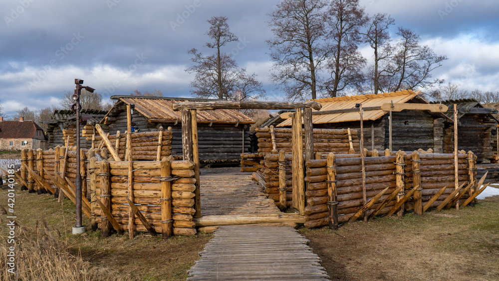 Araisi Lake Castle in Latvia. Historical Wooden Buildings on Small lake Island in the Frozen Lake Araisi in the Winter. Reconstruction of Wooden Fortified Settlement of Ancient European People Araisi Lake Castle in Latvia. Historical Wooden Buildings on Small lake Island in the Frozen Lake Araisi in the Winter. Reconstruction of Wooden Fortified Settlement of Ancient European People