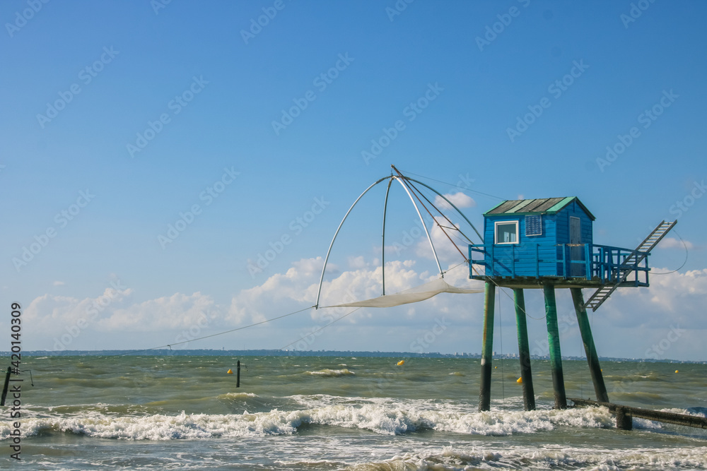 cabane de pêcheur bleue avec un filet à carrelet pour pêcher à marée haute sur la plage de Saint-michel-chef-chef cabane de pêcheur bleue avec un filet à carrelet pour pêcher à marée haute sur la plage de Saint-michel-chef-chef