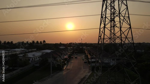 Transmission poles The electric poles travel through the high-voltage poles within the village and contrast with the beautiful sky at sunset. Energy efficiency concept