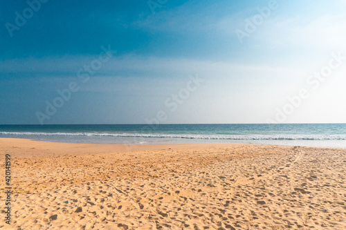 Tropikalna plaża z pięknym piaskiem i oceanem w tle.